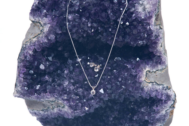 Brincos de cristal e pingente na cadeia de prata apresentado no geodídeo ametista
 - Foto, Imagem