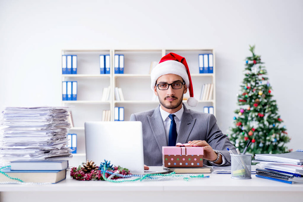 Νεαρός επιχειρηματίας γιορτάζει τα Χριστούγεννα στο γραφείο - Φωτογραφία, εικόνα