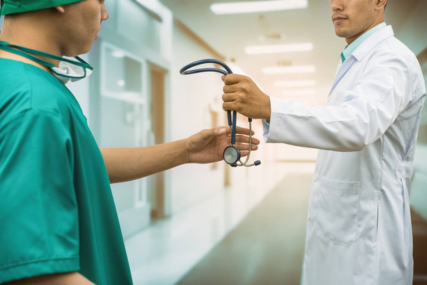 Doctor giving stethoscope to surgeon (Referral) - Photo, Image