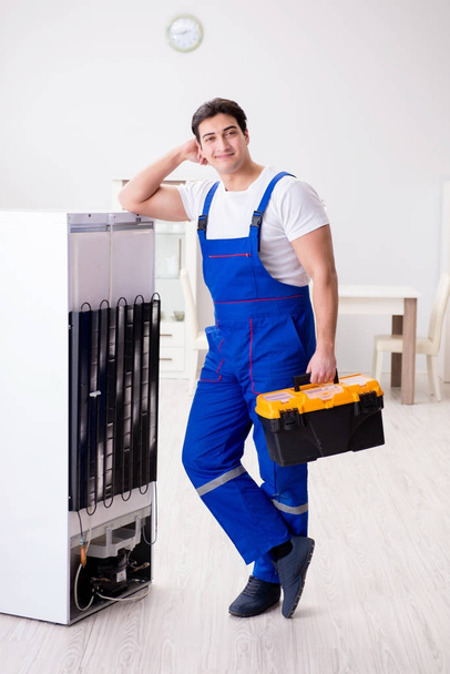 Repairman contractor repairing fridge in DIY concept - Photo, Image