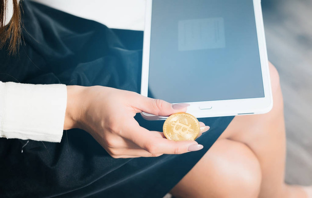 girl holds a tablet and coins, electronic money, bitcoins, crypto currency - Φωτογραφία, εικόνα