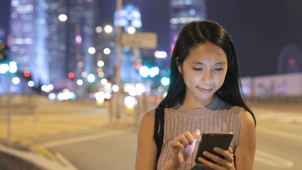 Mulher enviando SMS no celular na cidade
  - Foto, Imagem
