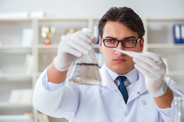 Νεαρός ερευνητής επιστήμονας που κάνει μια δοκιμή νερού expe μόλυνση - Φωτογραφία, εικόνα