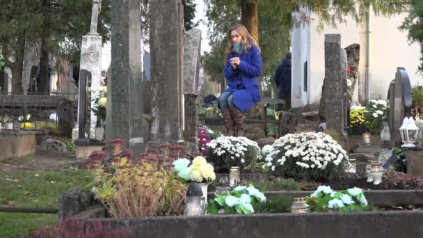 żałoba w pobliżu marmurowy nagrobek na cmentarzu w jesień kobieta. 4k - Materiał filmowy, wideo
