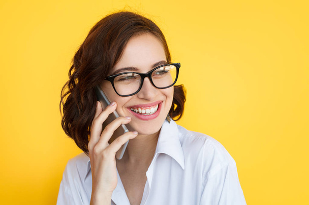 Laughing girl in eyeglasses talking phone - Foto, afbeelding