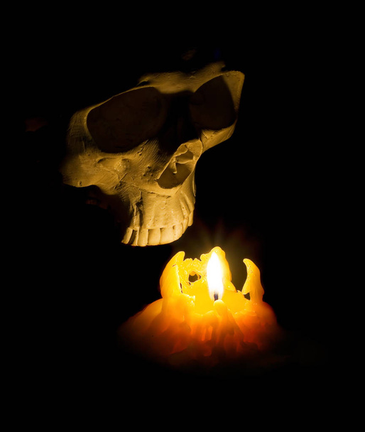 Halloween fantôme crâne humain sort de l'obscurité allumée avec une bougie
 - Photo, image