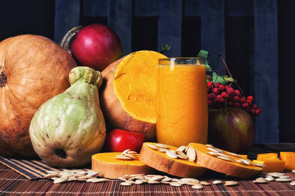 delicious fresh pumpkin juice with the seeds in the Studio on wooden background - Photo, Image