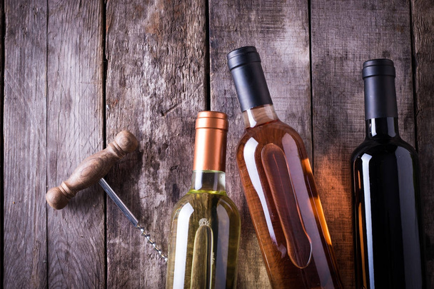 red,pink and white bottle of wine on wooden table background. still life concept - Valokuva, kuva