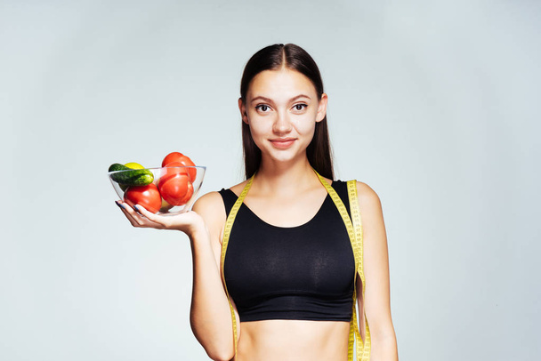 el plato contiene buena comida productos vegetarianos. Mujer atractiva sosteniendo un plato con verduras rojas verdes
 - Foto, imagen