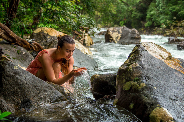 la jeune fille boit l'eau d'un ruisseau de montagne
 - Photo, image