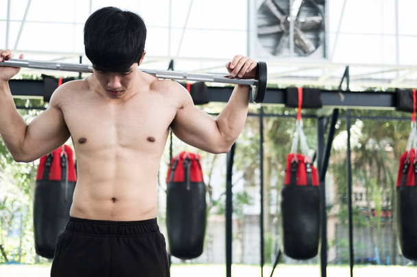 lihaksikas mies suorittaa liikuntaa kuntokeskuksessa. Urosurheilija pu
 - Valokuva, kuva