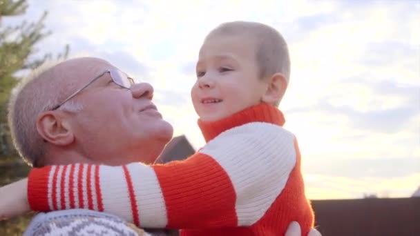 Grandfather and his grandson are watching airplane in the sky at sunset - Footage, Video