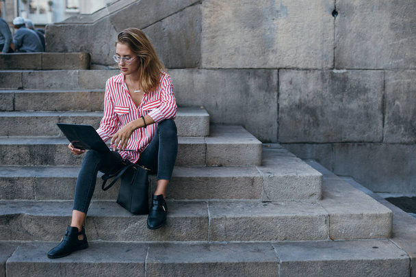 Woman sits on stairs of university with Laptop - Foto, Imagem