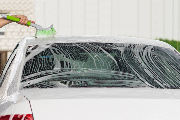 washing the roof of the car with foam on the car wash - Foto, Imagen