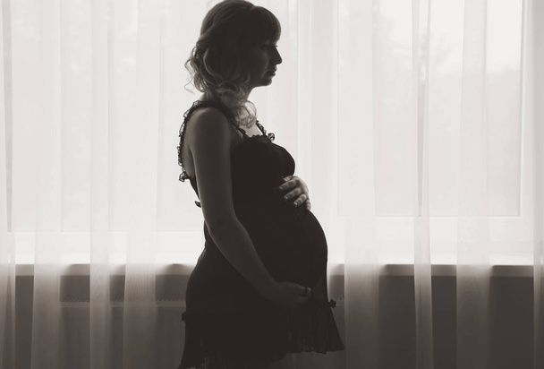 Egy terhes nő sziluettje  - Fotó, kép