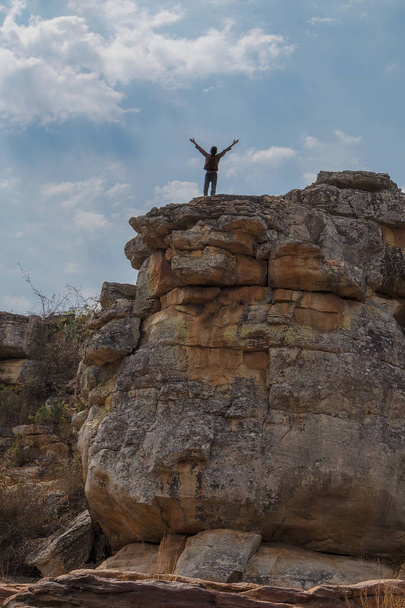 African kid on giant stone tops with open arms. Lubango. Angola. - Photo, Image