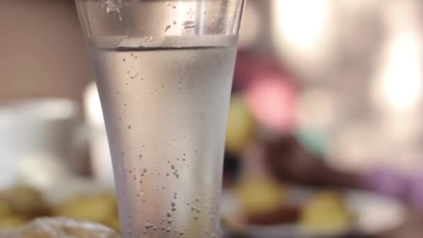 glass with mineral water on a table, rural breakfast from baked potato and sausages - Imágenes, Vídeo