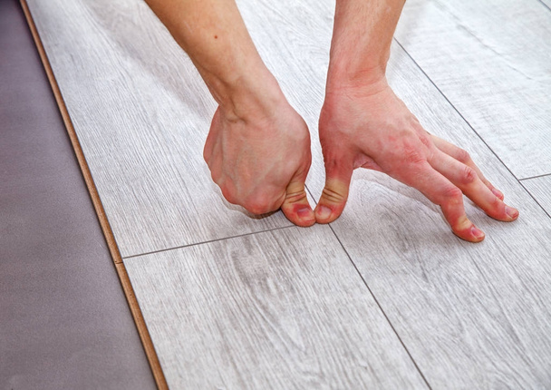 handyman laying down laminate flooring boards - Фото, зображення