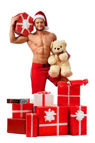 Handsome Santa Claus standing in a pile of presents - Photo, Image