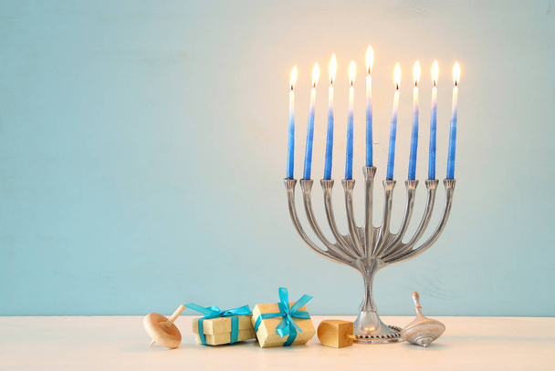 image of jewish holiday Hanukkah background with traditional spinnig top, menorah (traditional candelabra) - 写真・画像
