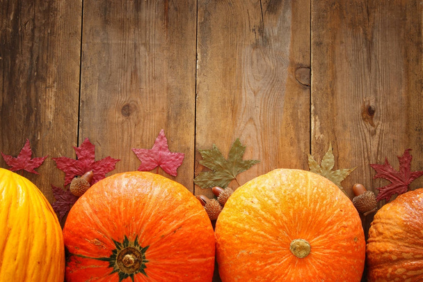 Pumpkins and autumn leaves on wooden background. thanksgiving and halloween concept. Top view - Foto, Bild