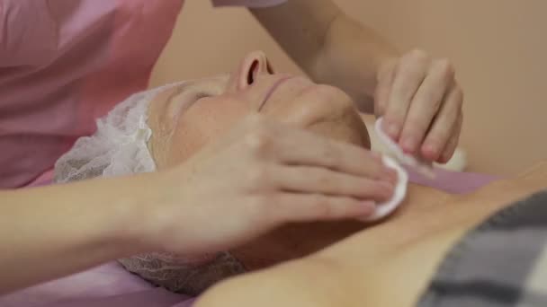 Kosmetikerin macht Gesichtsreinigung und Peeling - Filmmaterial, Video