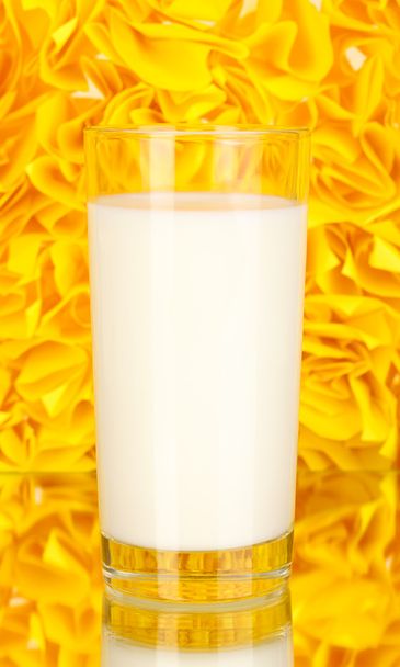 Glass of fresh new milk on decorative yellow background with reflection - Фото, изображение