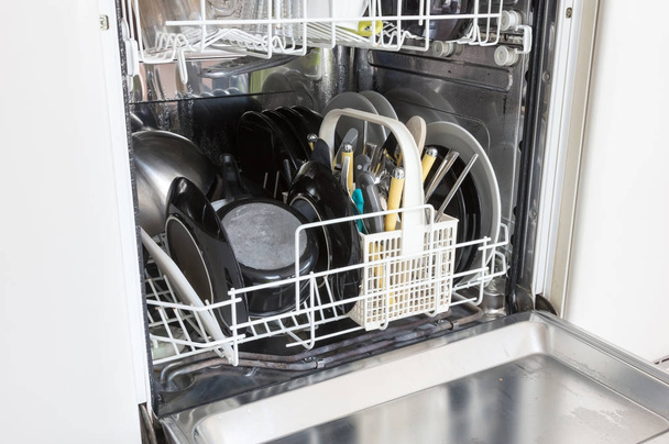 Open dishwasher with clean plates, cups and dishes - Foto, imagen