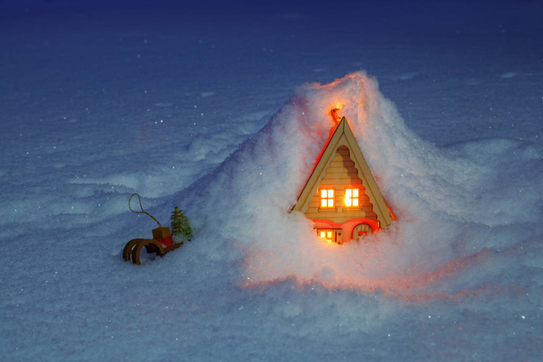 Casa giocattolo con slitta sotto un cumulo di neve
 - Foto, immagini