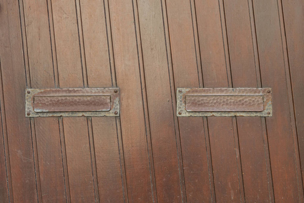 Puerta de madera con dos ranuras de correo
 - Foto, Imagen