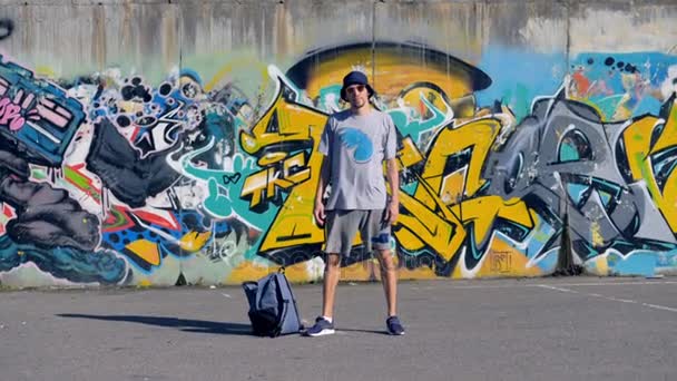 Ένας καλλιτέχνης γκράφιτι στέκεται ακόμα κοντά στο έργο του. - Πλάνα, βίντεο