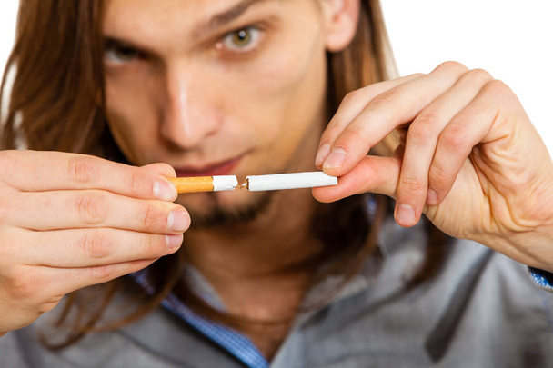 Junger Mann bricht sich eine Zigarette - Foto, Bild