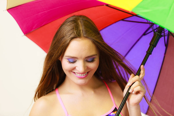 Woman standing under colorful rainbow umbrella - Фото, изображение