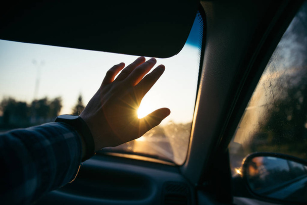 mies pitää kädestä auringon edessä auringonlaskun aikaan
 - Valokuva, kuva