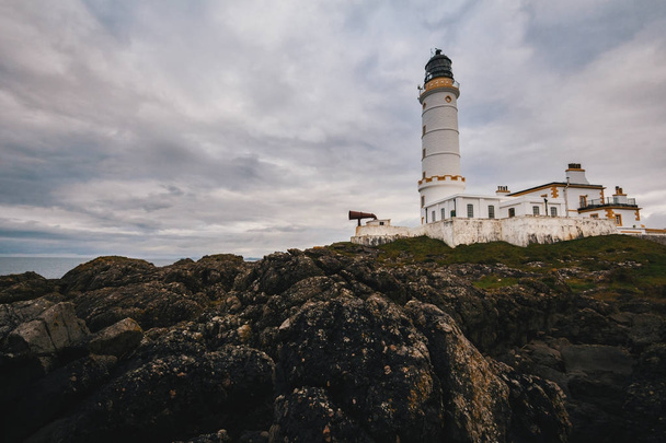 Old lighthouse on the rock coast of sea - Zdjęcie, obraz