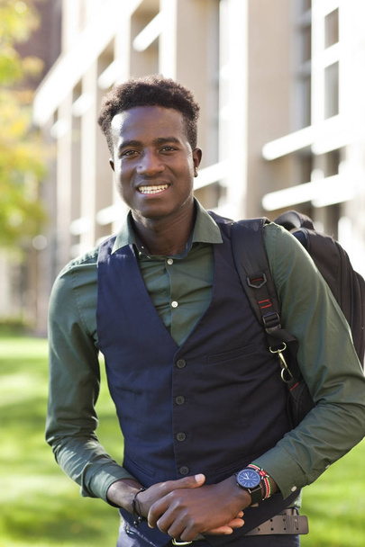 Bello giovane studente nero uomo sorride in piedi sul campo del college
 - Foto, immagini