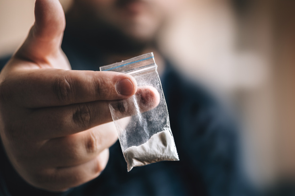 Traficante de drogas ofrece dosis de cocaína u otras drogas en bolsa de plástico, adicción a las drogas en concepto de fiesta
 - Foto, Imagen