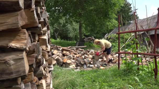 Pilha de madeira picada e homem agricultor preparar lenha no quintal. 4K
 - Filmagem, Vídeo