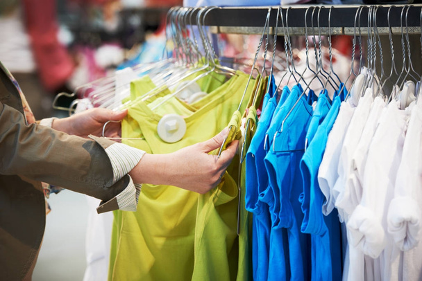 shopping. Woman hands choosing clothing - Φωτογραφία, εικόνα