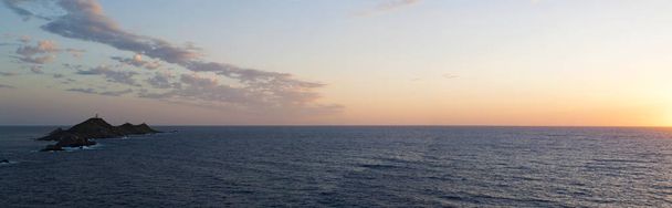 Córsega: o pôr do sol de tirar o fôlego sobre os Sanguinários de Iles (Ilhas Sangrentas), famosas quatro ilhas de pórfiro vermelho escuro, um pequeno arquipélago no Golfo de Ajaccio com um farol que data de 1844
 - Foto, Imagem