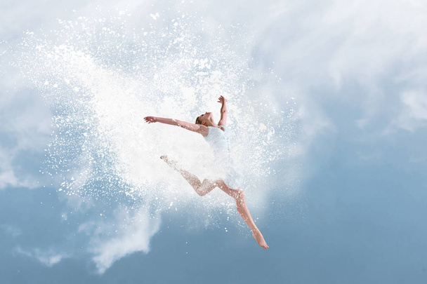 Beautiful ballet dancer jumping inside cloud of powder - Foto, Imagen