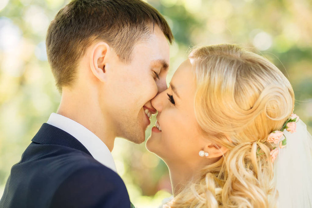 Closeup of beautiful happy couple kissing in the park - Photo, Image