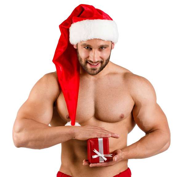 Muscular santa claus with small gift in hands on a white background - Фото, зображення