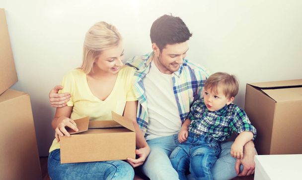 happy family with boxes moving to new home - Фото, изображение