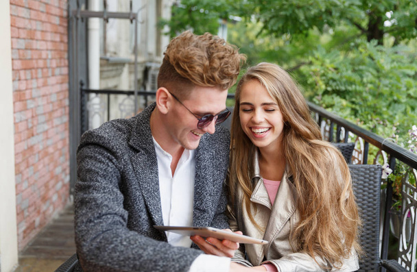 Cute young amorous couple with a digital tablet on a blurred background. New technology concept. - Foto, Bild