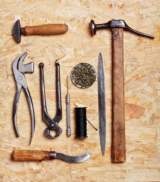 Set of cobbler vintage tools on the wooden background. Top view - Foto, Imagem
