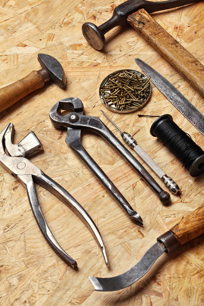 Set of cobbler vintage tools on the wooden background. Top view - Foto, Bild