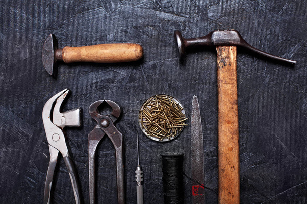 Set of cobbler vintage tools pliers, nippers, hook sewing, cobbler's hammer on the dark wooden background. Top view - Fotó, kép