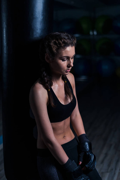 Järkyttynyt nuori nyrkkeilijä tyttö yllään nyrkkeilyhanskat istuu t
 - Valokuva, kuva