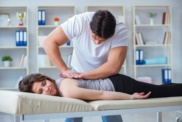 Young doctor chiropractor massaging female patient woman - Фото, зображення